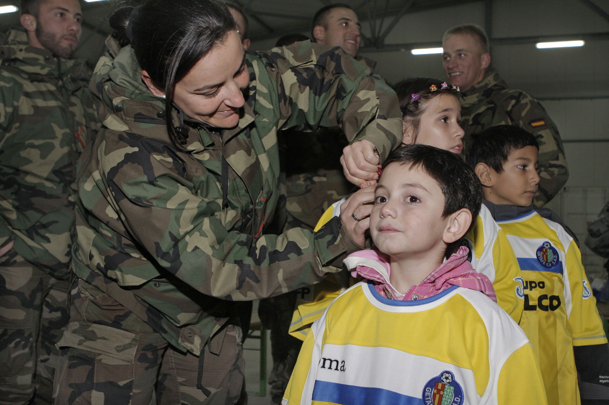 Militares españoles destinados en Camp Butmir, Sarajevo, con Vicente del Bosque entregan material deportivo y juguetes a niños de un orfanato